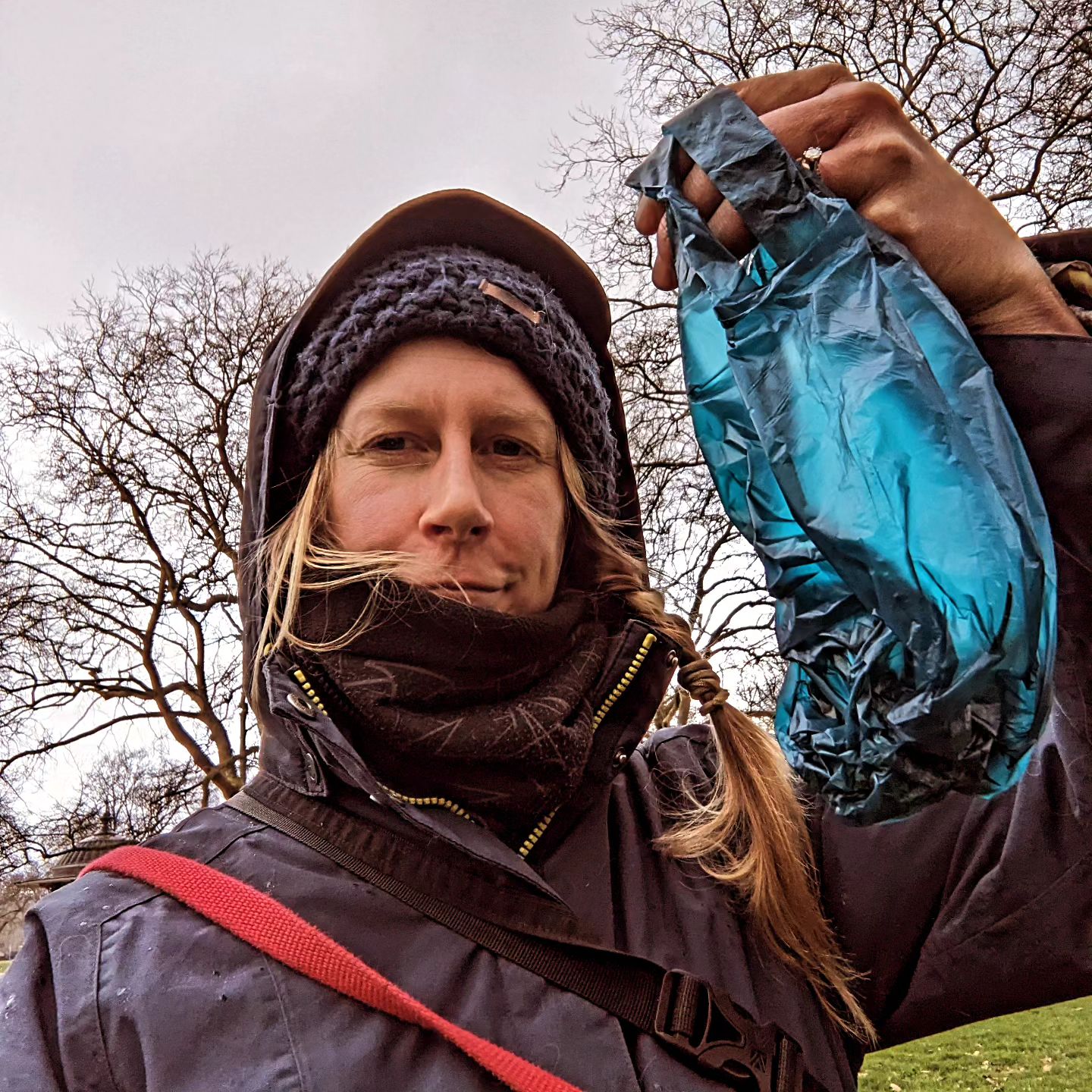 An image of a woman holding a reseacled poo bag
