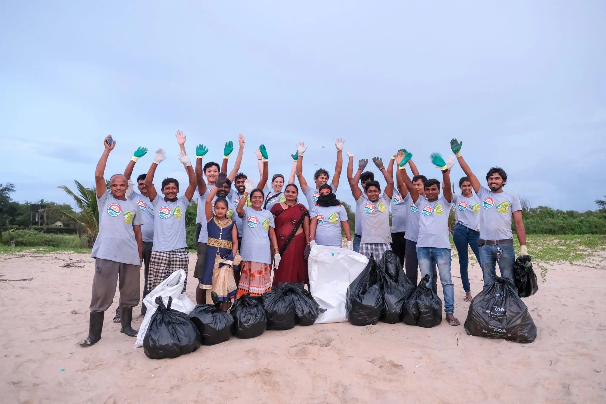 An image of a group of people celebrating collecting rubbish from a beach