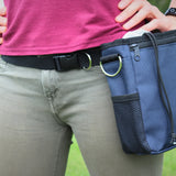 A photo of a dog treat pouch around a woman's waist