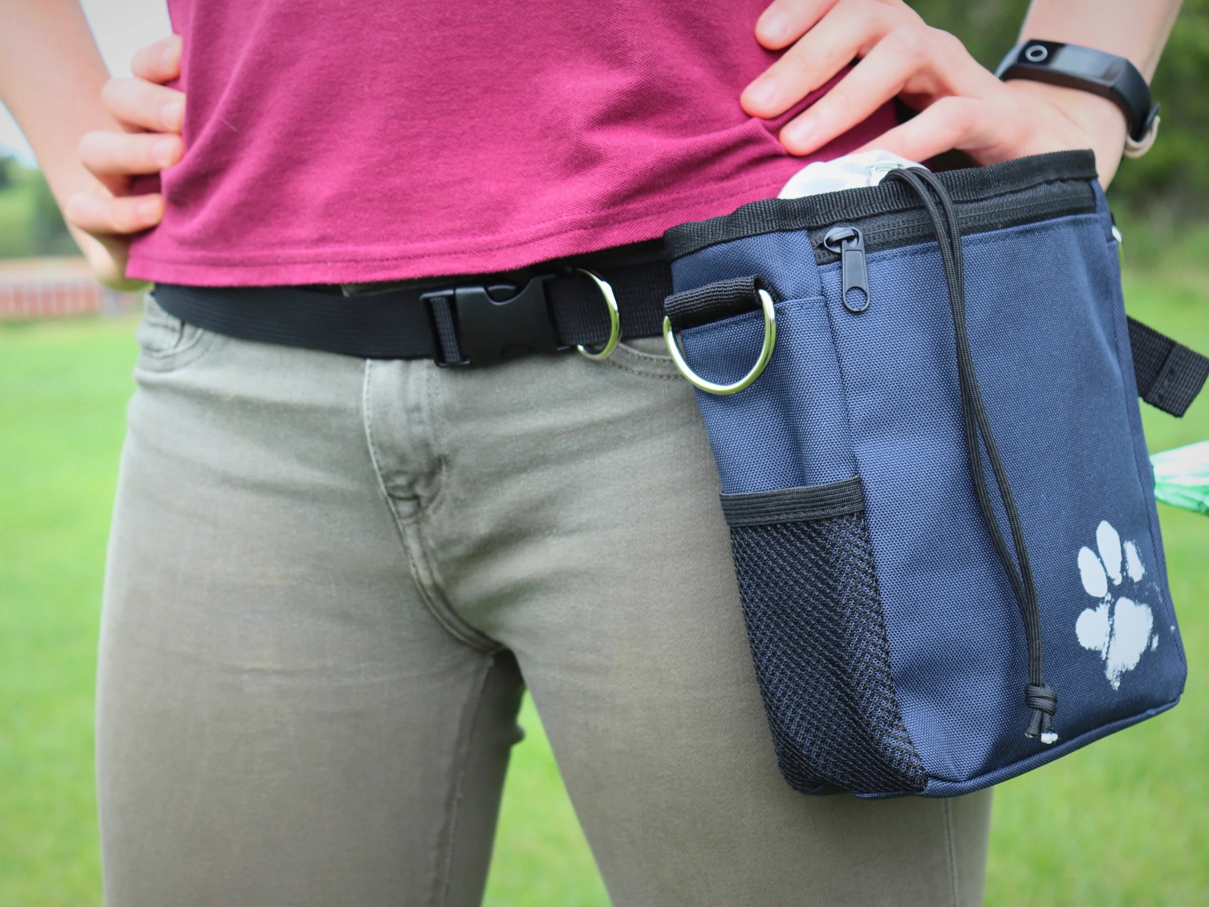 A photo of a dog treat pouch around a woman's waist