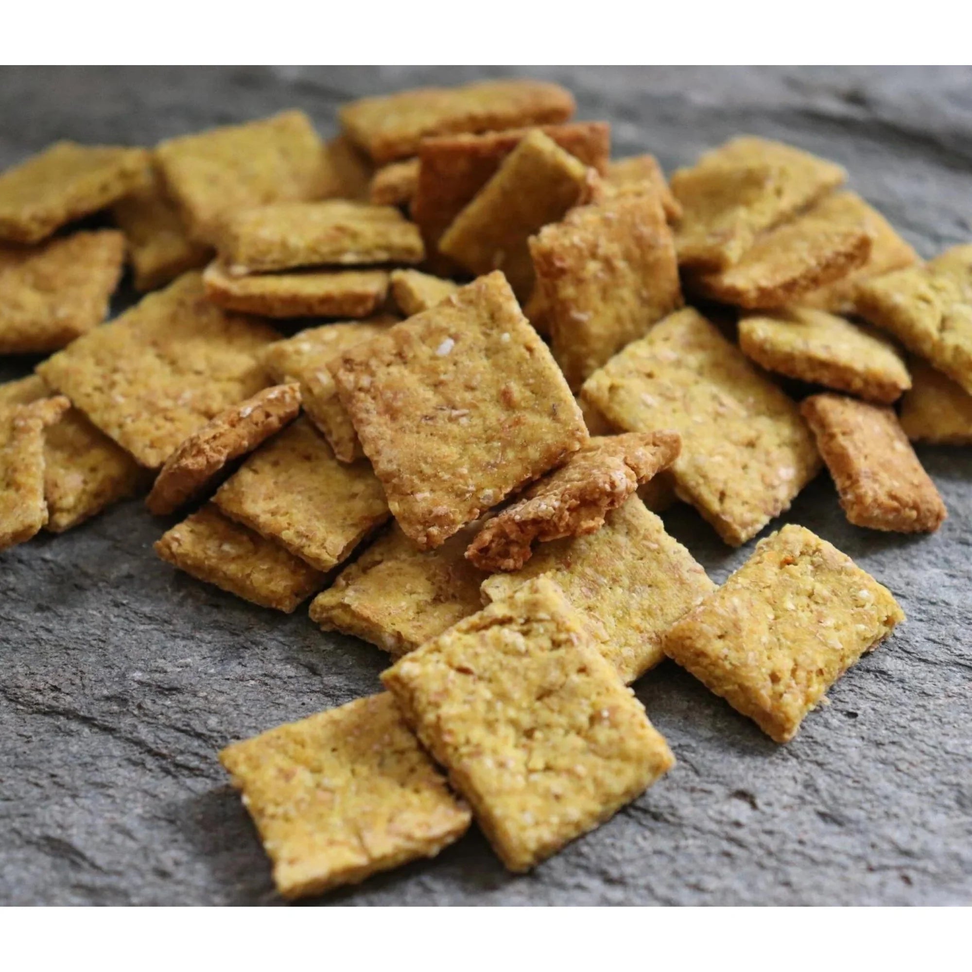 A picture of hand baked crunchies dog treats on a grey slate background