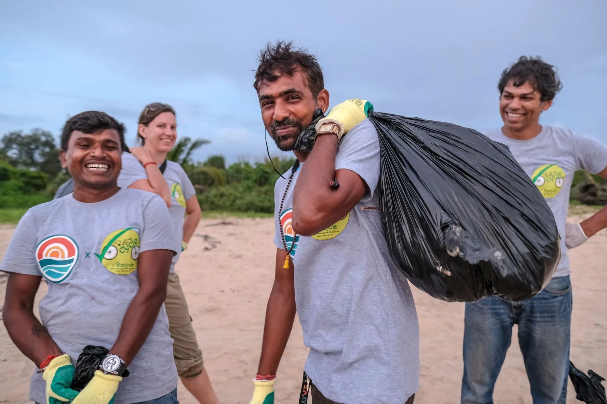 An image of four people collecting rubbish from a beach