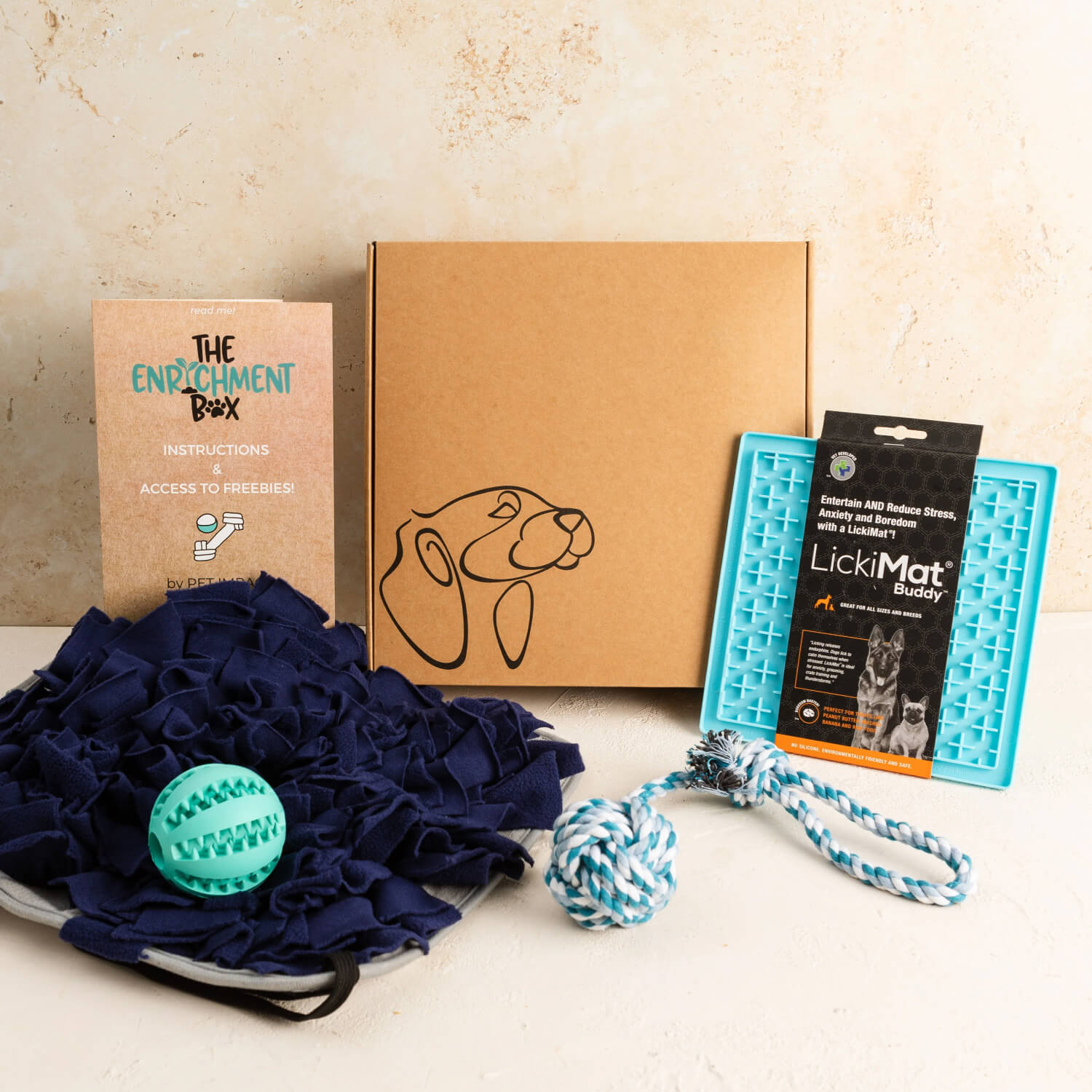 The enrichment box contains a snuffle mat, lickimat, rubber treat ball and a rope toy